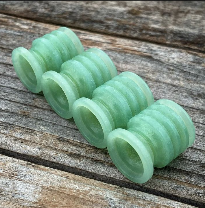G10 lanyard bead attached to folding knife with paracord showing proper bore diameter fit, stopper knot placement, and color-matched knife scale coordination
