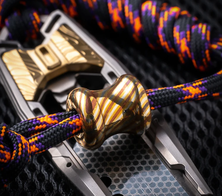 Close-up of Damascus steel bead bore hole showing chamfered edges and interior finish for paracord compatibility