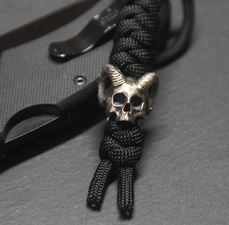 Different skull bead designs including horned, crowned, cracked, and sugar skull styles for paracord projects