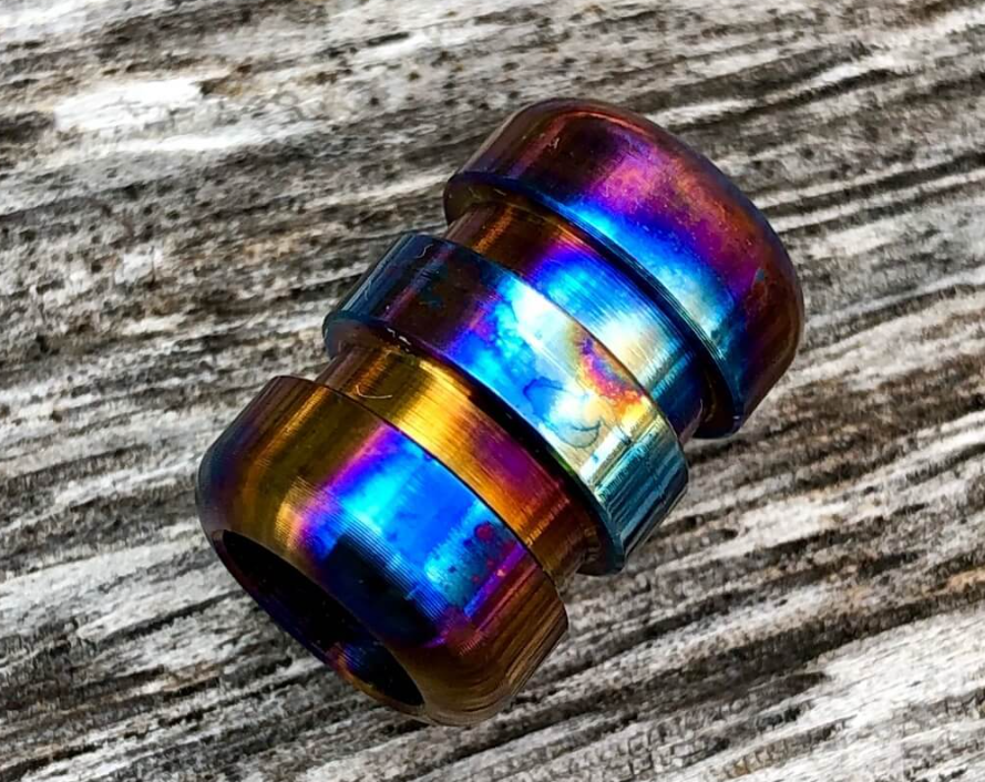 Hand polishing titanium bead with wet sandpaper showing proper circular motion technique and water lubrication