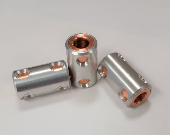 CNC machined paracord beads in titanium and brass with precision bore diameter for 550 cord threading
