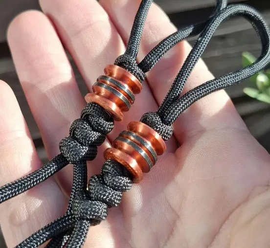 Close-up of paracord lanyard bead hole showing smooth chamfered edges versus rough unfinished edges